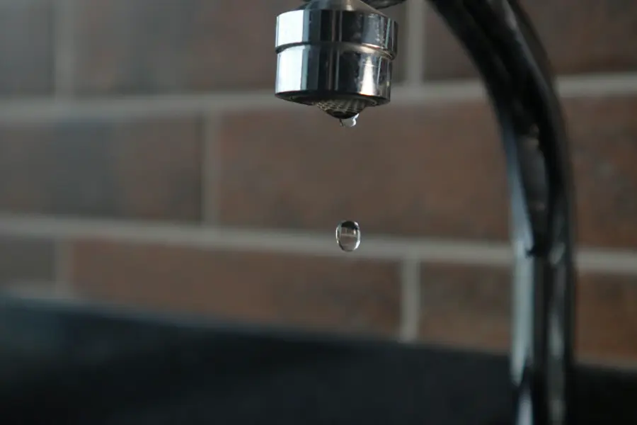 A dripping tap with a drop of water about to fall.